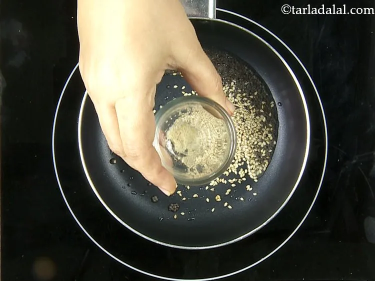 Step 25 – When the seeds crackle, add the sesame seeds and asafetida.
