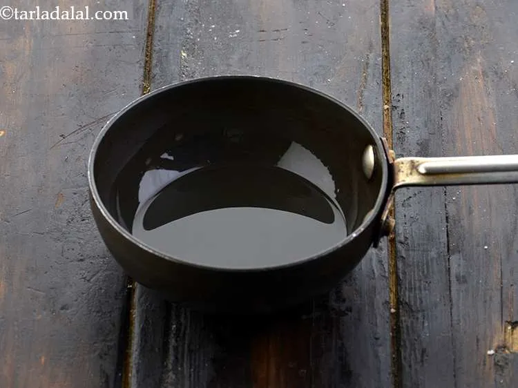Step 21 – For the tempering of the <strong>poha dhokla</strong>, heat the oil in a small pan.&nbsp;