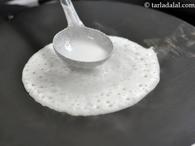 Step 27 – Pour a ladleful of the <strong>poha dosa</strong> batter on it.