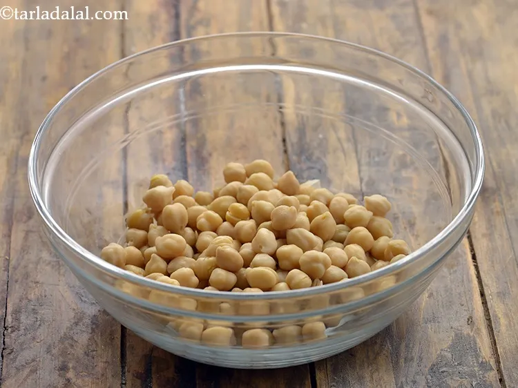 Step 9 – To make the&nbsp;<strong>Potato and Chana Salad, </strong>place the <a href="https://www.tarladalal.com/glossary-kabuli-chana-290i" target="_blank">kabuli chana</a> in a deep …