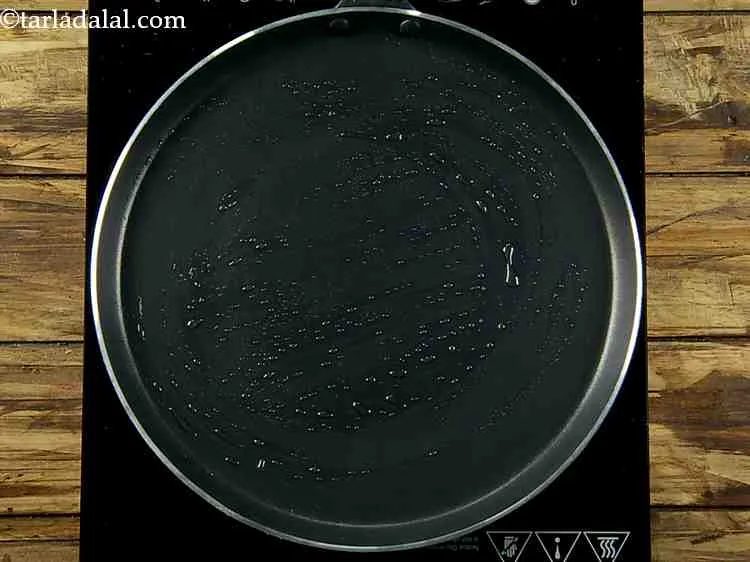 Step 19 – Heat a non-stick tava (griddle), grease it with 1 tsp of oil.&nbsp;