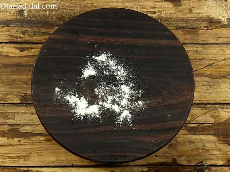 Step 6 – Take a rolling board and sprinkle a little whole wheat flour on it.&nbsp;