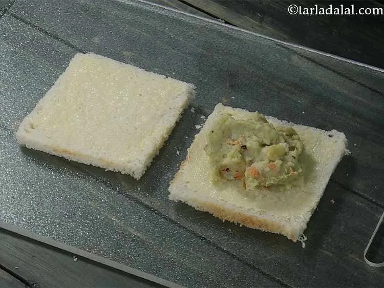 Step 13 – Place a portion of the prepared stuffing on one buttered bread slice.