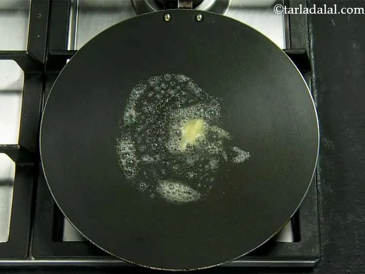 Step 17 – Heat ? tsp of butter on a non-stick tava (griddle).