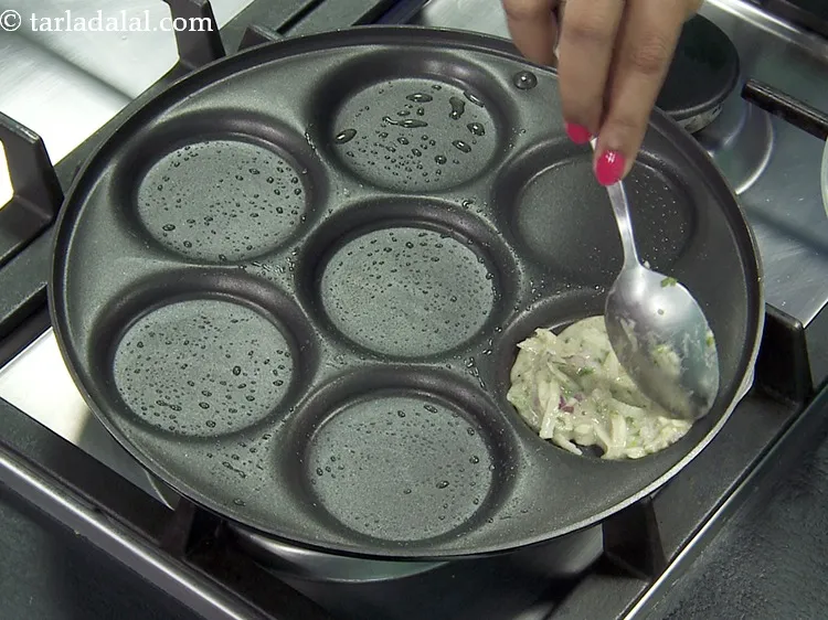 स्टेप 18 – प्रत्येक ७ उत्तपम सांचों में एक चम्मच बैटर डालें।