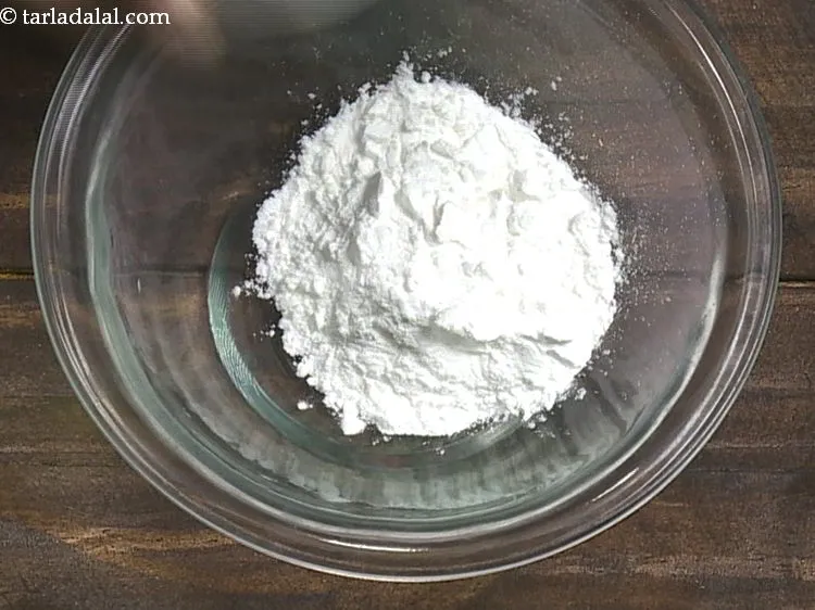 Step 1 – To make a slurry for <strong>potato cheese-stuffed balls</strong>, in a bowl take cornflour.