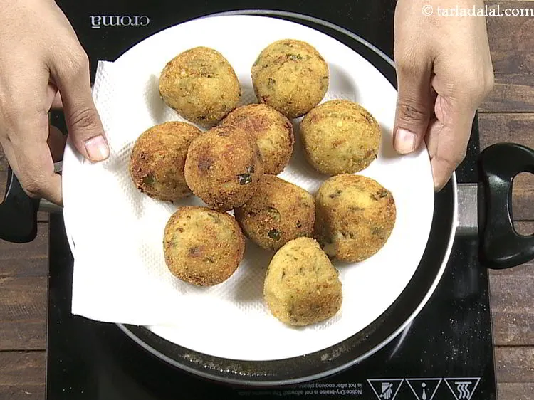 Step 23 – With the help of a slotted spoon, remove the <strong>potato cheese-stuffed balls</strong> and drain on …