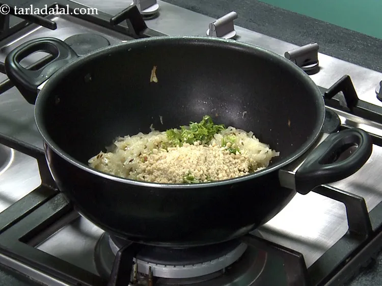 Step 21 – Add 1/4 cup&nbsp;<a href="https://www.tarladalal.com/glossary-roasted-and-crushed-peanuts-1817i">roasted and coarsely crushed peanuts</a>. See above how to make peanut powder.