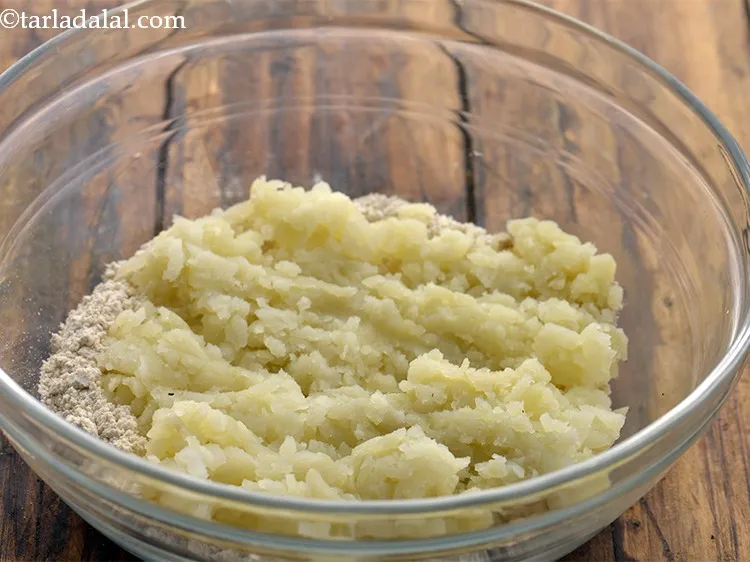 स्टेप 3 – कद्दूकस किया हुआ आलू डालें।