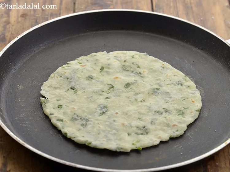 Step 14 – Heat a non-stick tava (griddle) and carefully place the <strong>Potato Roti</strong> over it. Cook the …
