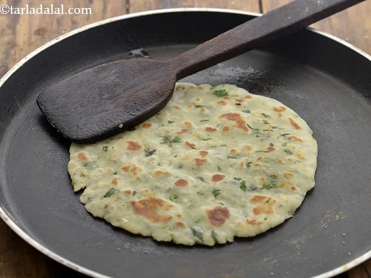 Step 16 – Apply 1/2 tsp oil on the other side and cook till the potato roti has …