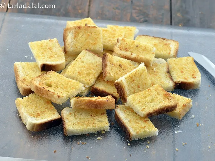 Step 8 – Place the bread slices on a clean, dry surface and cut each toasted garlic slice …