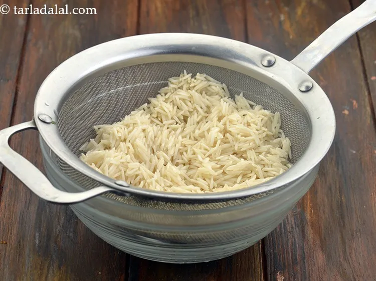 Step 11 – After half an hour, drain the rice and keep aside.