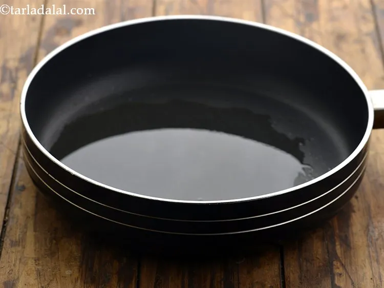 Step 4 – For making the <strong>Punjabi aloo puri</strong>, heat the oil in a broad non-stick pan.