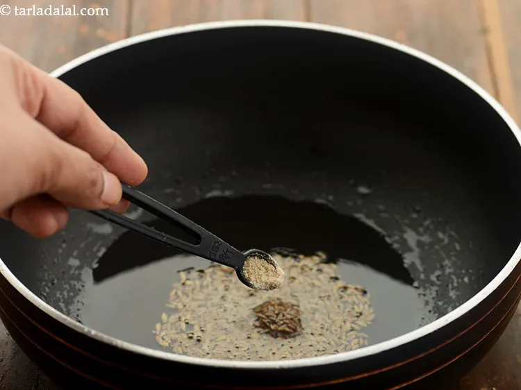 Step 7 – When the seeds crackle, add the asafoetida. Hing is one of the main flavoring ingredients …