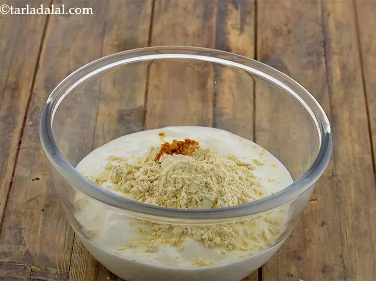 Step 12 – With that add the <em>besan</em> and turmeric powder.