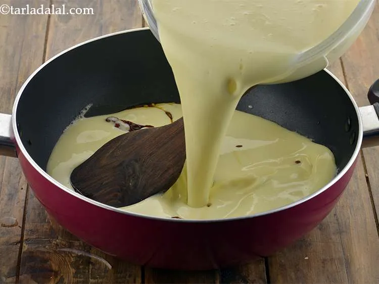 Step 18 – Reduce the flame to low and add the prepared curd mixture to the kadhai.