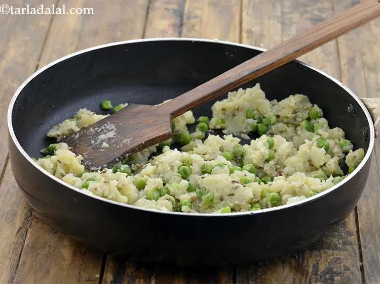 Step 13 – Then add the boiled green peas. Learn <a href="https://www.tarladalal.com/How-To-Microwave-Green-Peas-22505r">how to microwave green peas.</a>