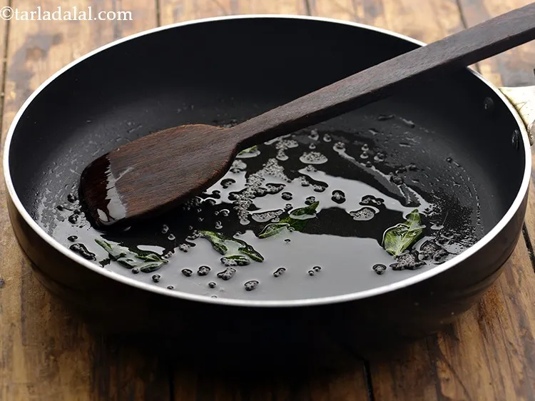 स्टेप 6 – जब सरसों चटकने लगे, कडी पत्ते डालें और मध्यम आंच …