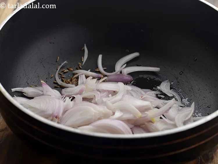 Step 6 – When the seeds crackle, add onions.