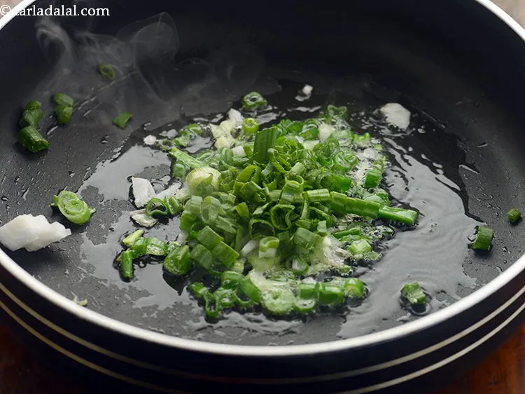 Step 8 – Add the spring onion whites and greens. Spring onions would give crunch to our noodles.&nbsp;