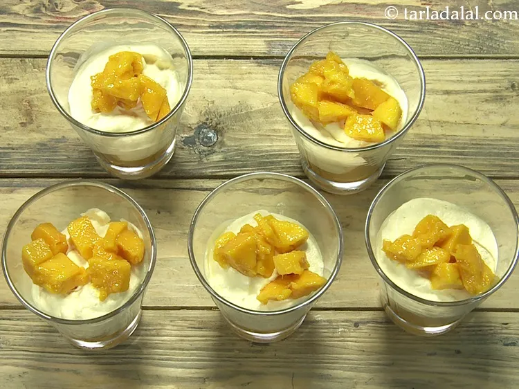 स्टेप 18 – इसके ऊपर प्रत्येक गिलास में&nbsp;१&nbsp;टेबल-स्पून&nbsp;<a href=""https://www.tarladalal.com/glossary-chopped-mango-hindi-803i"">कटा हुआ आम</a>&nbsp;<a href=""https://www.tarladalal.com/glossary-chopped-mango-803i"" style=""font-family:Arial; …