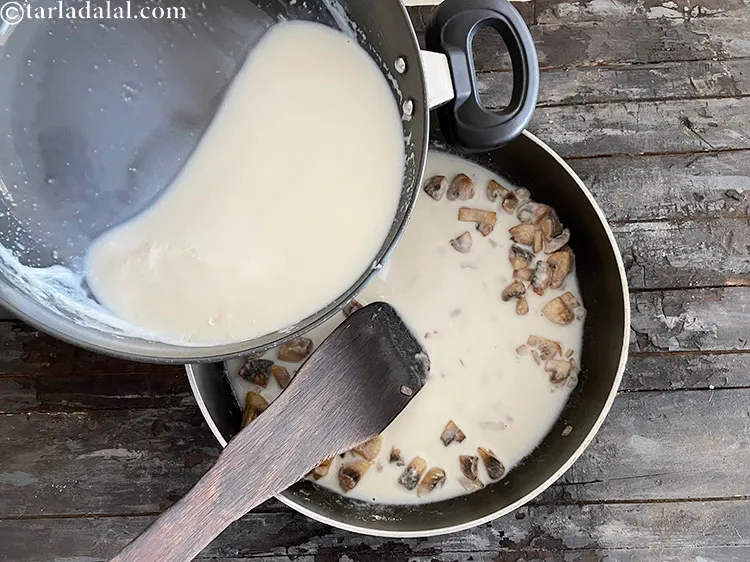 स्टेप 14 – धीरे-धीरे चम्मच से हिलाते हुए दूध-पानी का मिश्रण डालें।