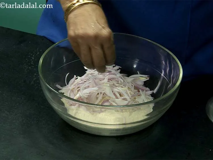 स्टेप 2 – प्याज़ डालें। यह थालीपीठ को एक अच्छा क्रंच देता है।