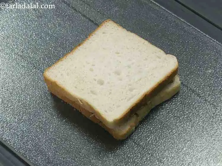 Step 11 – Sandwich it using another bread slice with the buttered side facing downwards.