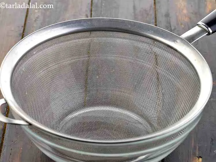 Step 5 – For a <strong>5-minute shrikhand recipe</strong>, place a strainer over a deep bowl. Ensure the bowl …