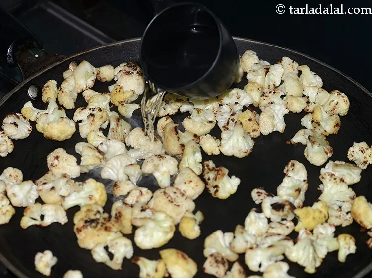 स्टेप 7 – ४ टेबलस्पून पानी छिड़कें छिड़कें। इसे फूलगोभी के फूल जले …