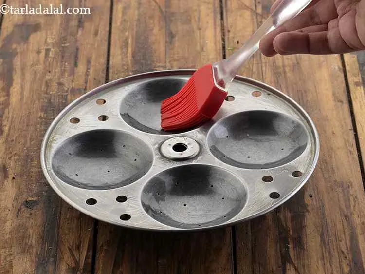 स्टेप 14 – इडली के सांचों को तेल से चिकना कर लें, ताकि …