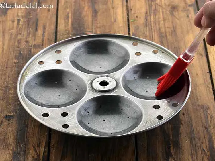 Step 18 – Grease the idli moulds using oil.