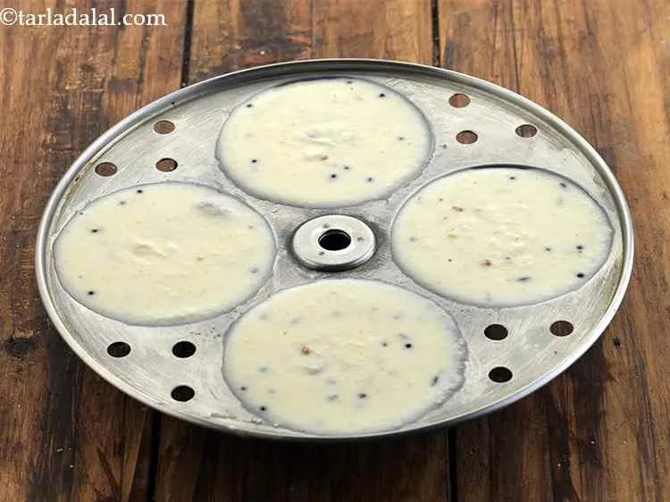 स्टेप 17 – प्रत्येक घी वाले इडली मोल्ड में थोड़ा सा घोल डालें।