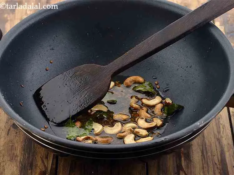 स्टेप 4 – कड़ी पत्ता और काजू डालें। एक मिनट के लिए भून …