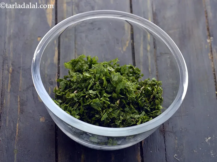 Step 29 – For the stuffing of aloo pattice, in a deep bowl, add the mint leaves.&nbsp;