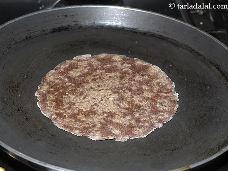 Step 17 – Cook on a hot tava (griddle) on a slow flame till pale brown spots appear …