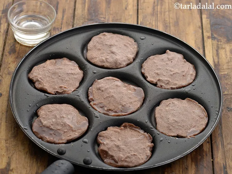 Step 23 – Increase the flame to medium, pour 1 tsp of oil along the edges of uttapas.