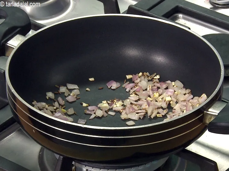 Step 42 – Add the garlic and onions and dry roast on a medium flame for 1 minute.