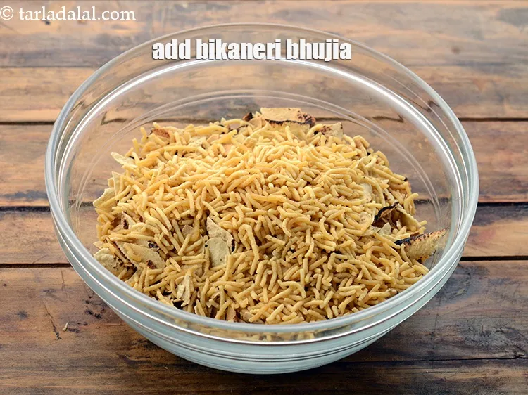 Step 8 – Add 1/4 cup&nbsp;<a href="https://www.tarladalal.com/bikaneri-bhujia-3860r">bikaneri bhujia</a>. You get this readymade in the market.&nbsp;