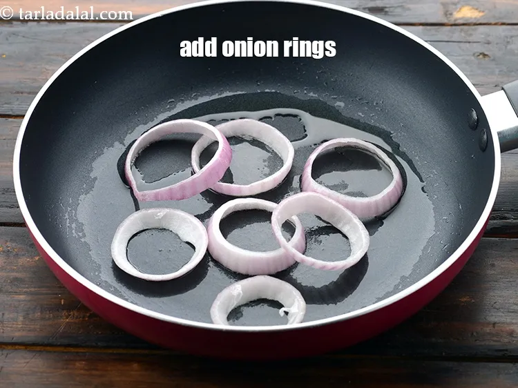 Step 51 – Add 8&nbsp;<a href="https://www.tarladalal.com/glossary-onion-rings-987i">onion rings</a>.