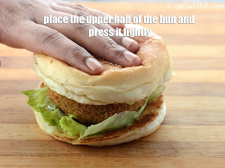 Step 73 – Place the upper half of the bun over it with the spread side facing down …