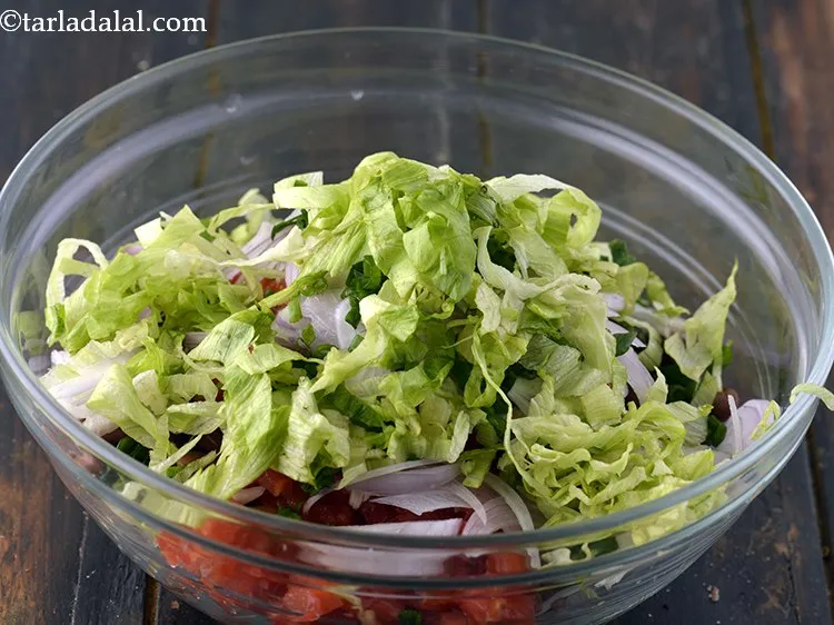 Step 13 – Add shredded iceberg lettuce to the <strong>rajma salad</strong>.&nbsp;