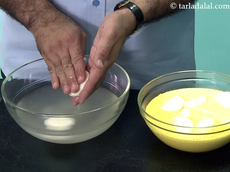 Step 27 – Remove the rasgulla one by one from the sugar syrup, squeeze them gently in between …