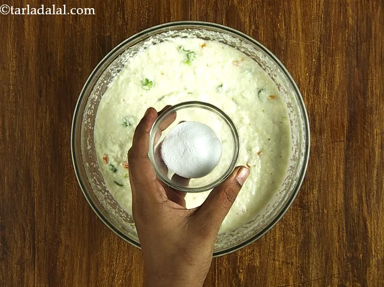 Step 17 – Just before steaming the&nbsp;<strong>Rava Vegetable Dhoklas</strong>, add the fruit salt. We have used a neutral …