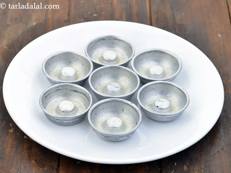 Step 13 – Grease all the dhokla moulds with 1 tsp&nbsp;<a href="https://www.tarladalal.com/glossary-oil-671i">oil</a>. We have also used mini dhokla …