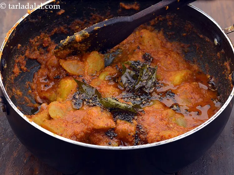 Step 33 – Pour the tempering over the <strong>raw mango curry</strong> and mix gently.