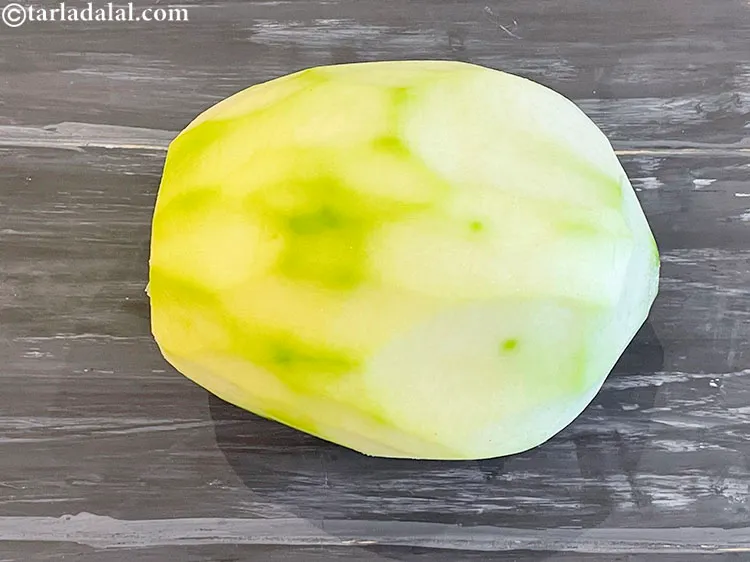 Step 4 – Peel the raw papaya.&nbsp;Remove the top and bottom&nbsp; skin off the papaya with a knife.&nbsp;