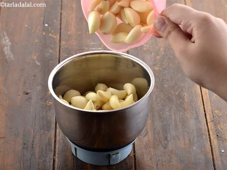 Step 29 – Add the peeled garlic cloves in a small mixer jar.