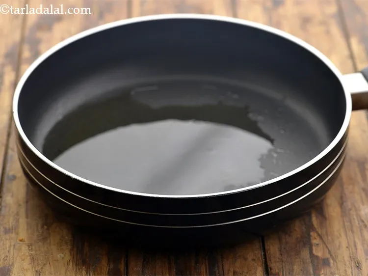 Step 11 – For making <strong>rice noodles with vegetables</strong>, heat the oil in a broad non-stick pan.